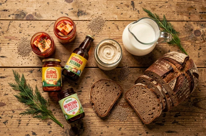 Vue aérienne d'une sélection d'aliments fermentés tendance incluant kimchi, kombucha et pain au levain sur une table en bois